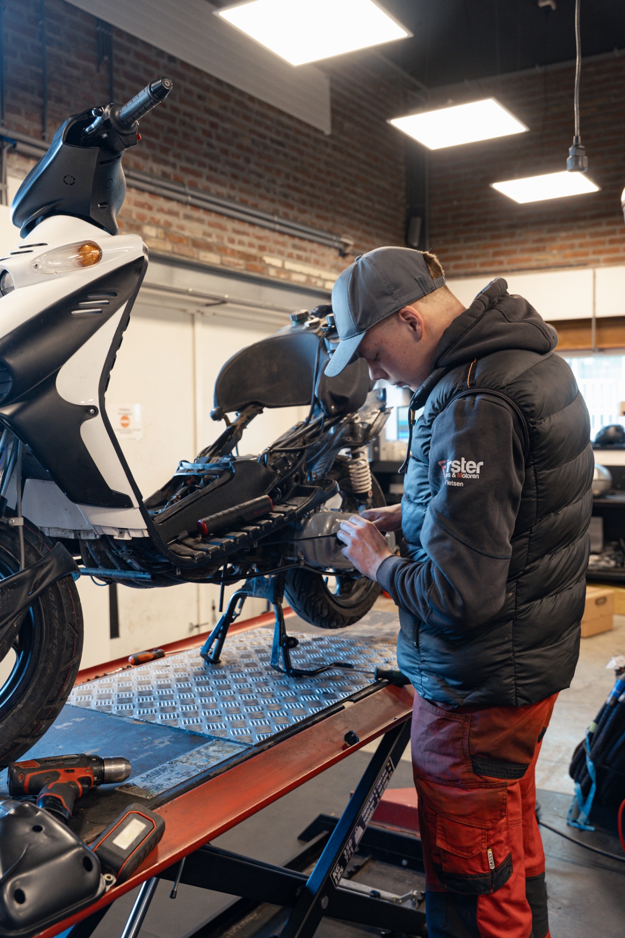 Monteur werkt aan een scooter in de werkplaats